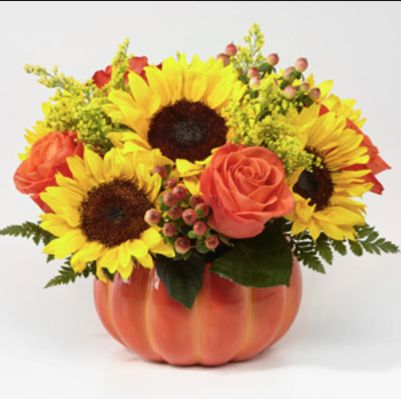 Harvest Traditions - Who doesn't love season flowers in a lovely Classic, Ceramic Pumpkin!  It's that time folks to celebrate the Harvest Season!  Sunflowers, Roses, Hypericum Berries and more in this wonderful piece ready for your table!  ***Pumpkin container is a pale, matt orange***