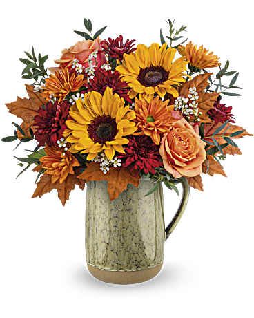 Harvest Season Bouquet - Like the autumn sun's warmth, this delightful sunflower bouquet is elegantly showcased in a food-safe stoneware pitcher adorned with a neutral green reactive glaze.