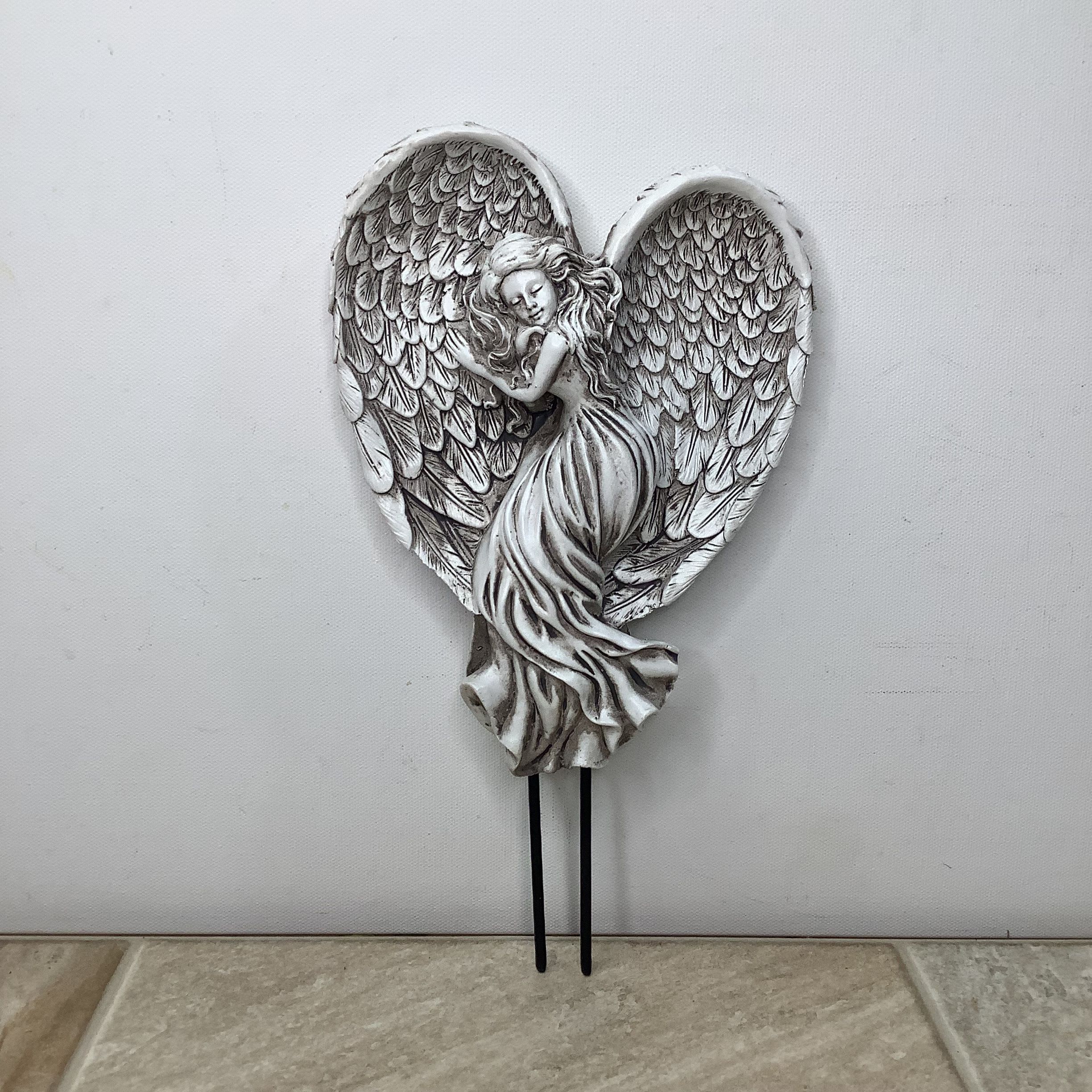 Silver angel figurine with large wings on a heart-shaped plaque