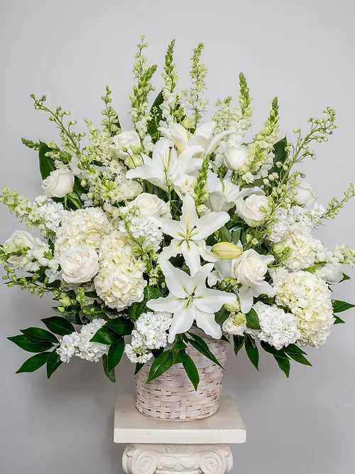 Our majestic standing basket arrangement - Symbolizing peace, serenity and purity, white flowers can help comfort those grieving the loss of someone they loved dearly. Our majestic standing basket arrangement in angelic white is an impressive tribute to their memory. 