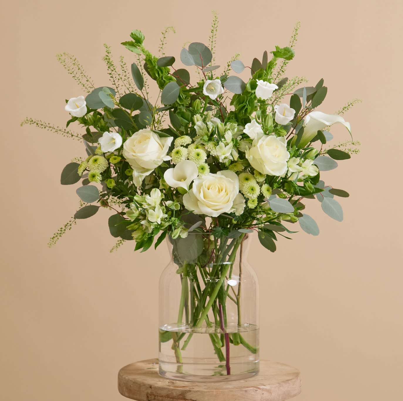 Fresh airy  arrangement - Fresh, airy, and crisp, this arrangement’s colour combination induces a soothing and calming atmosphere. Pearl-white alstroemeria, avalanche roses, and campanula are balanced with lime green santinis, greenbell, and molucella, while cream-white calla lilies add warmth to a backdrop of silvery eucalyptus.