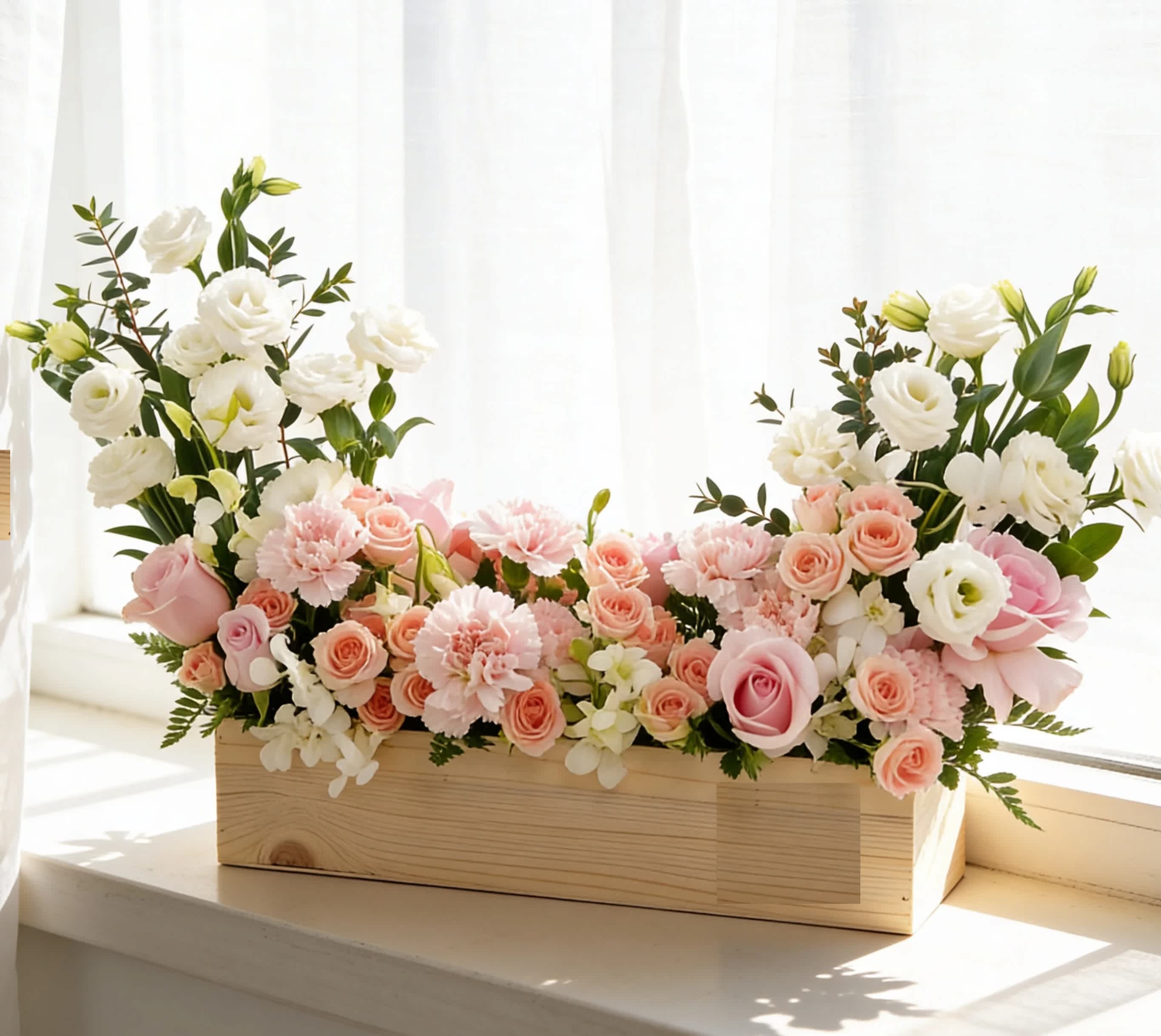 Pink and white floral arrangement in a wooden box