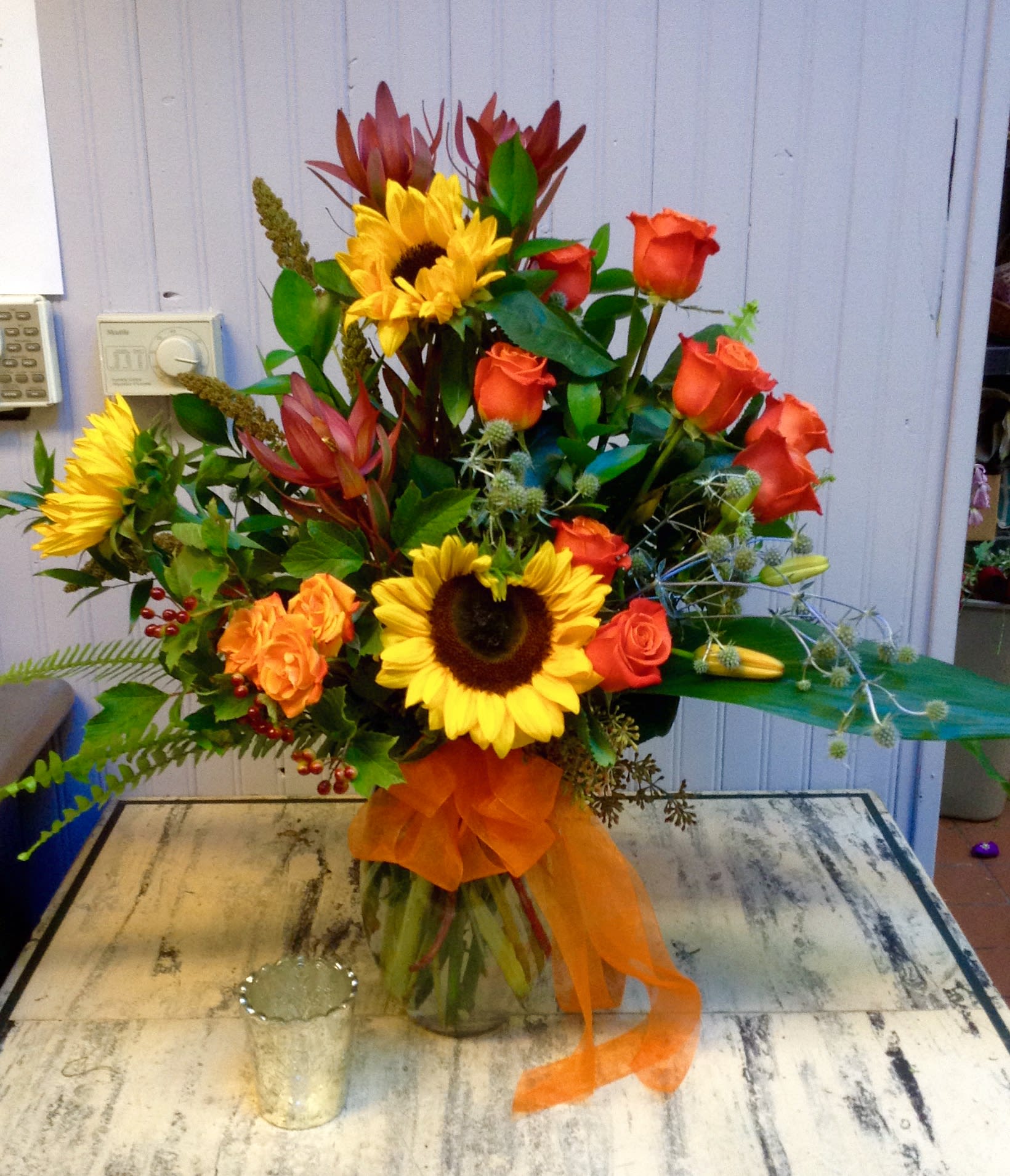 Autumn Spice - Large seasonal vase filled to the brim with autumnal favorites, including sunflowers roses lucedendron, lily, cranberry viburnum, millet and assorted greenery.