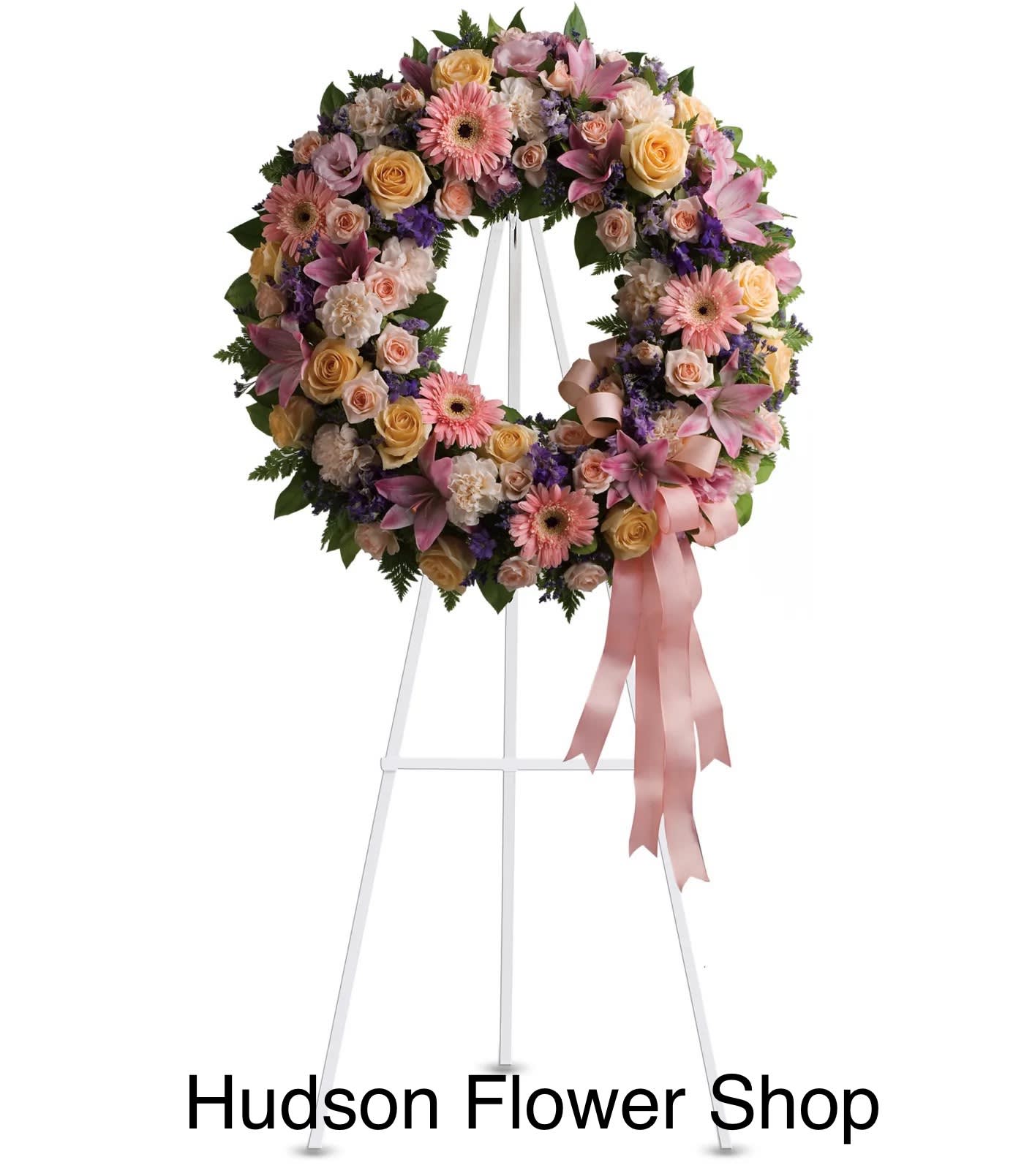 Pastel floral wreath on a white easel with pink ribbon