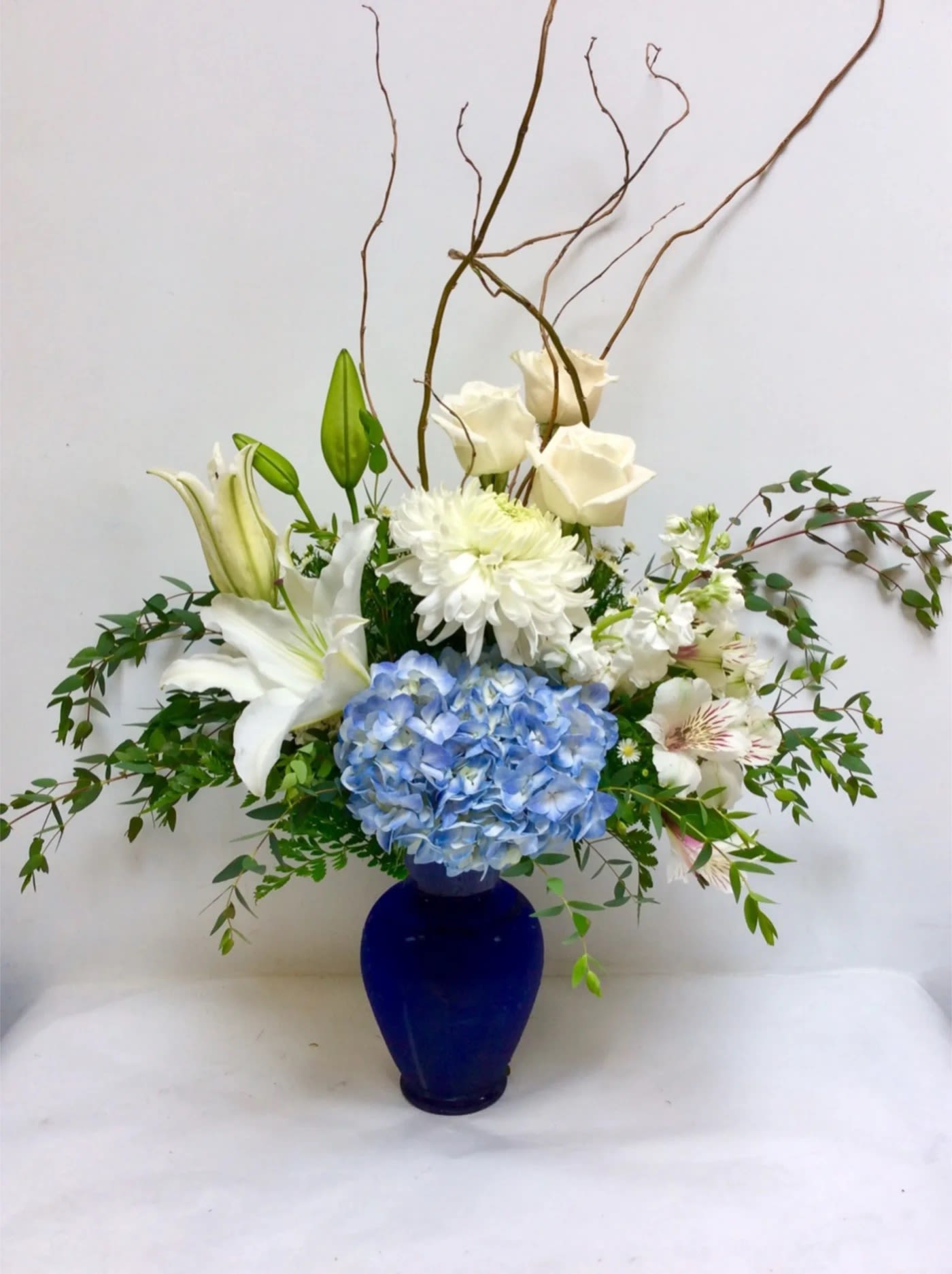 Blue and white floral arrangement in a cobalt vase