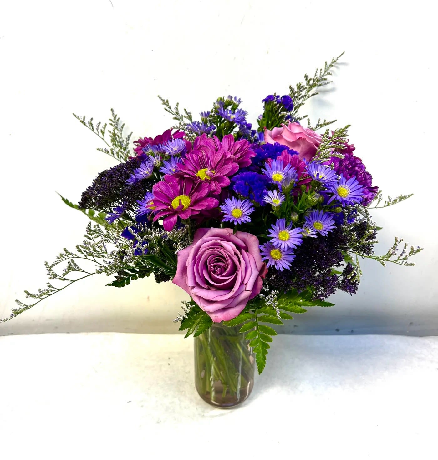 Purple and pink mixed bouquet in a glass vase