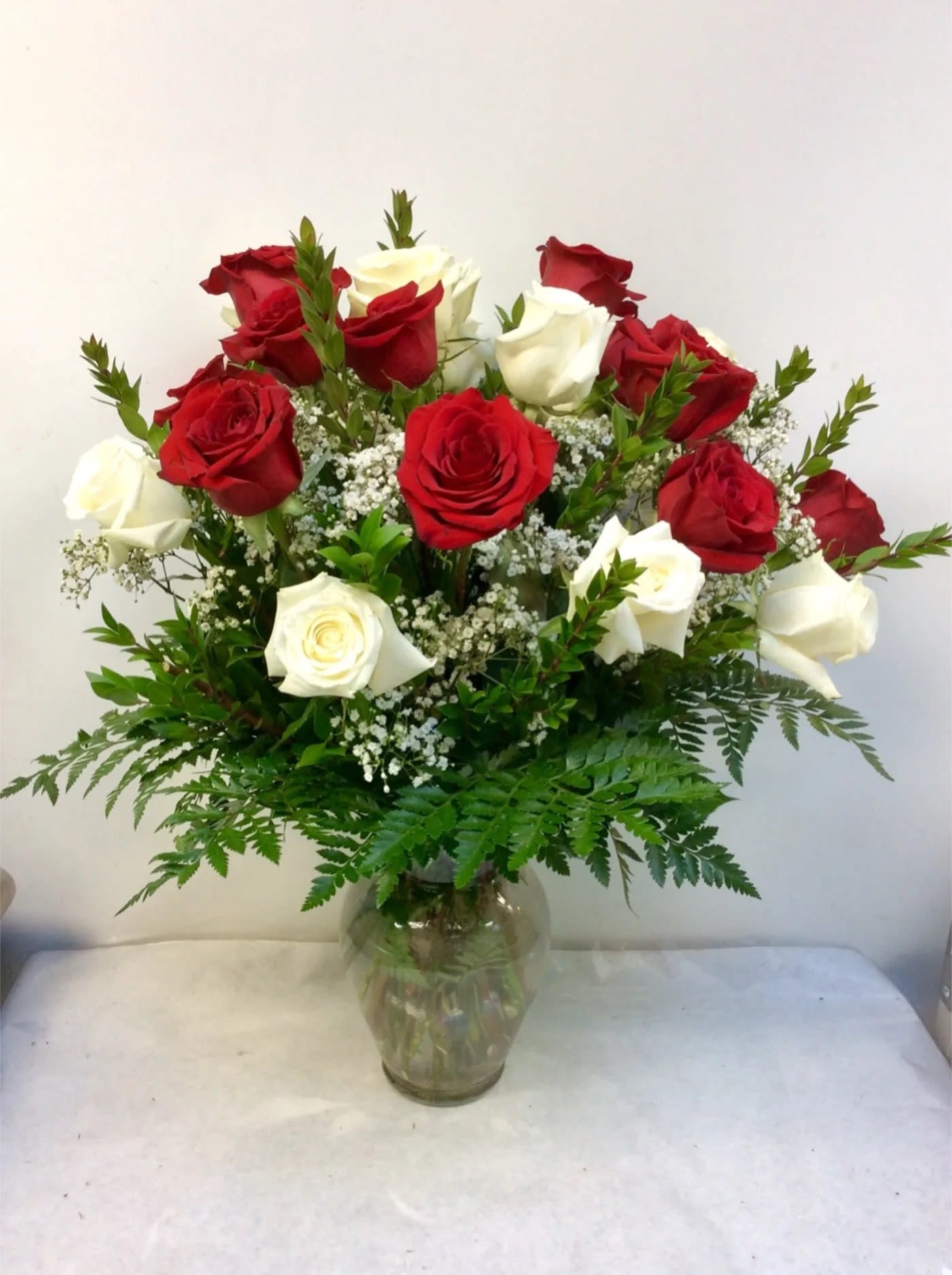 Red and white roses arranged in a clear glass vase