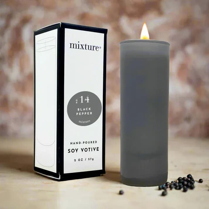 Gray soy votive candle beside its box with peppercorns