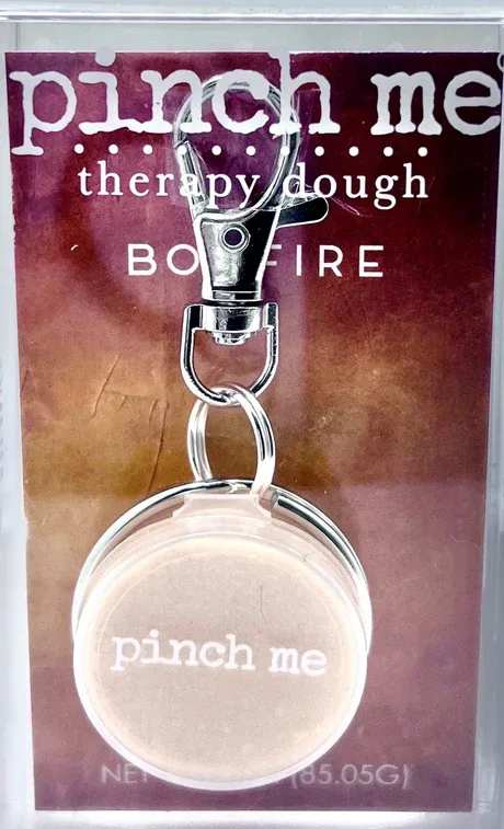 Keychain with a round beige charm on a printed card