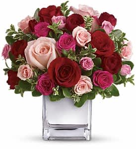 Teleflora's Love Medley Bouquet with Red Roses - Sing her a love song - with flowers. This lush, loving rose arrangement tells her just how much you care.  The stylish bouquet features large red and pink roses accented with smaller spray roses in shades of red and pinks. Delicate green oregonia and pittosporum add a fresh contrast, and all comes arranged and delivered in our exclusive Mirrored Silver Cube vase.  Approximately 10 1/2" W x 11" H