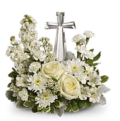 Divine Peace - An elegant display of faith and divine peace, this beautiful arrangement will comfort the bereaved in a truly thoughtful and respectful way. Stems: White roses, alstroemeria, stock, carnations and waxflower, dusty miller and iegated pittosporum. Flowers and colors may vary due to stock variance. Vase: Crystal Cross Keepsake Size: Approx. 13 ½" H x 14 ½" W Orientation: One-Sided