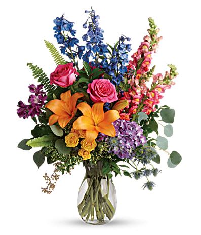 Colors of the Rainbow - A rainbow of beauty for any occasion. Purple hydrangea, pink roses and orange lilies positively pop in this bright bouquet, featuring all the colors of the rainbow. This colorful bouquet includes purple hydrangea, pink roses, yellow spray roses, orange asiatic lilies, purple alstroemeria, blue delphinium, pink snapdragons, blue eryngium, huckleberry, oregonia, Israeli ruscus, sword fern, silver dollar eucalyptus, seeded eucalyptus, and lemon leaf. Delivered in a jordan vase. 