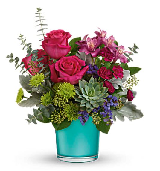 Pink roses and purple flowers in a turquoise glass vase