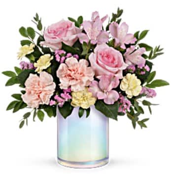 Pink and cream flowers arranged in an iridescent glass vase
