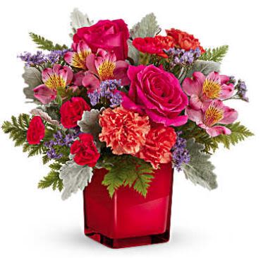 Garden Harmony - You'll be captivated by the vibrant beauty of Teleflora's Garden Harmony Bouquet, a bold mix of colorful blooms artfully arranged in the striking Scarlet Color Splash Cube. A dazzling display of joy and elegance, it's the perfect way to brighten any space with warmth and charm!  Teleflora's Garden Harmony Bouquet features hot pink roses, orange spray roses, pink alstroemeria, orange carnations, red miniature carnations, purple limonium, dusty miller, and leatherleaf fern. Arranged in the striking Scarlet Color Splash Cube, this vibrant bouquet is a bold and joyful gift.