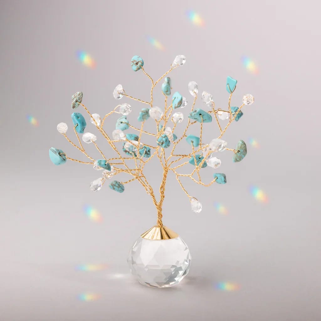 Decorative gold wire tree with turquoise and clear crystals in a faceted glass base