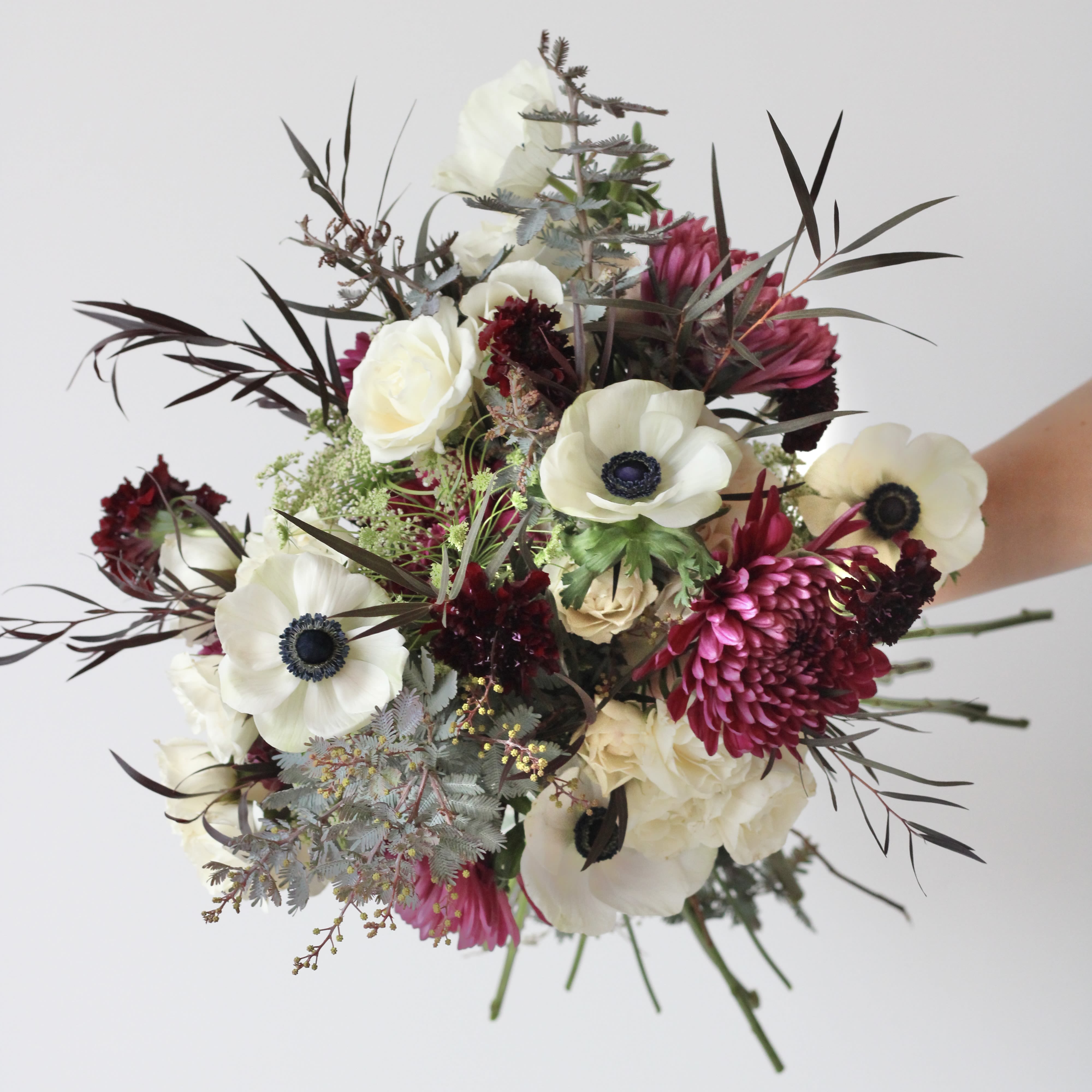 Bouquet of white and magenta flowers with dark foliage