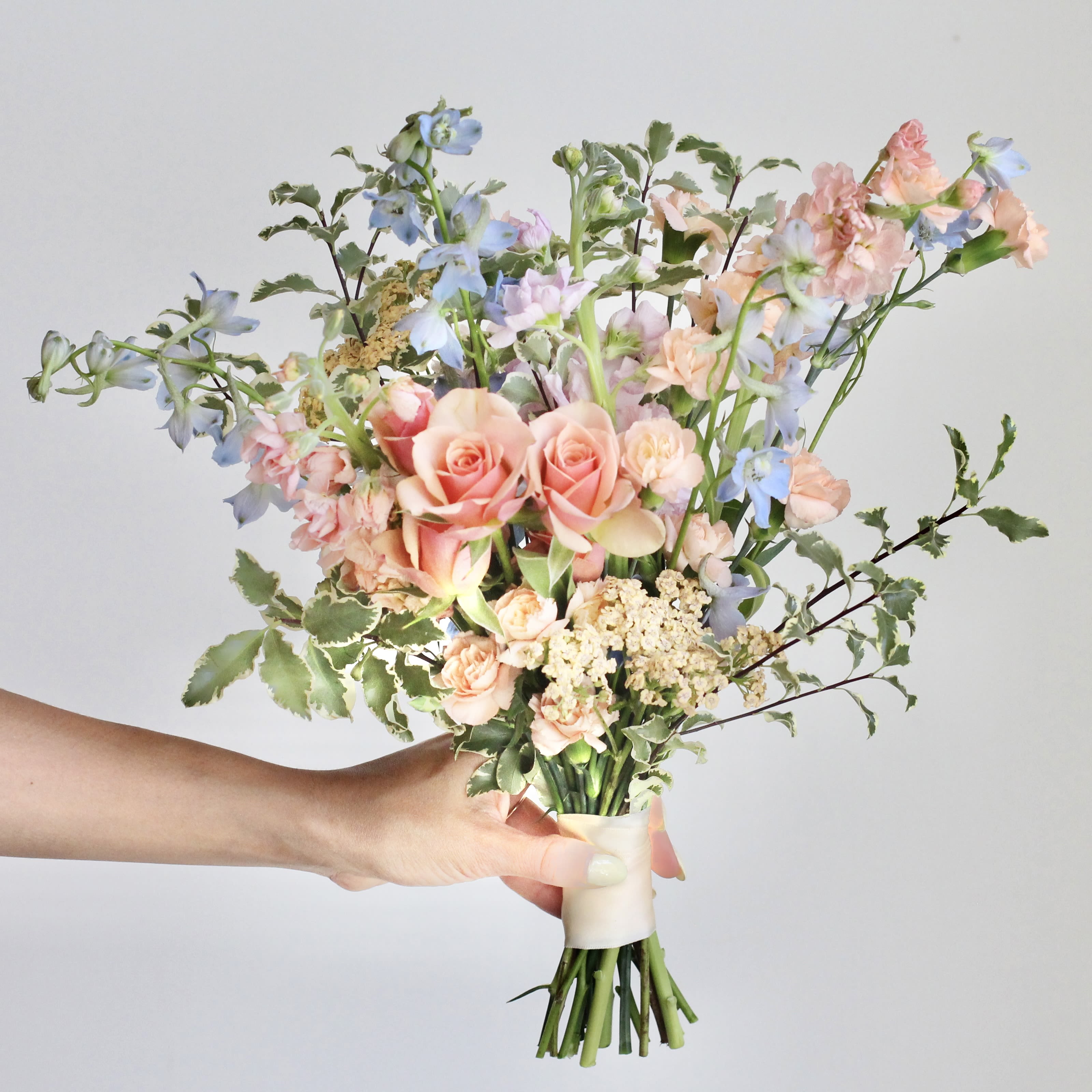 Pastel Petite Bouquet - Elevate your celebration with the beauty of coordinated sophistication with Middlemist's A la Carte Events! This thoughtfully curated collection features products in harmonized color palettes. Create a polished look, knowing every piece complements the other perfectly. Minimum purchase of $300 required to order from the A La Carte menu.  Walk down the aisle with a touch of soft romance! Our Pastel Petite Bridesmaid Bouquet is a delicate blend of blush pinks, warm peaches, gentle purples, and airy blues, creating a dreamy and elegant bouquet. Perfectly sized for a graceful accent, this bouquet exudes charm and sophistication, making it an enchanting complement to your special day.  The Details:  -Please allow at least 2 weeks notice so we can source the freshest, most beautiful blooms for your arrangements. -Custom requests are not available for À La Carte orders. If you have specific ideas, please check out our Custom Event page or contact us directly. --Changes or additions to your order must be made no later than 7 days prior to the pick-up date. --Enjoy free pick-up at our studio Monday through Friday. Weekend pick-ups are available for an additional $200 and must be scheduled by appointment.  **Cancelation Policy: Orders canceled within the 2-week window are non-refundable. Refunds are available only for cancellations made 3+ weeks before the event date.  We’re here to make your event feel as special and unforgettable as possible—just leave the floral magic to us!