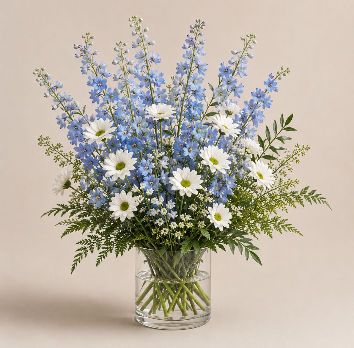Blue skies  - This tall blue and white arrangement is a breezy breath of summer air in an interesting vase. Featuring goldenrod, delphinium, and white daisy poms this arrangement is a sweet summer gesture. Send it for birthdays or as a just-because surprise.  Approximate Dimensions: 18"D X 32"H
