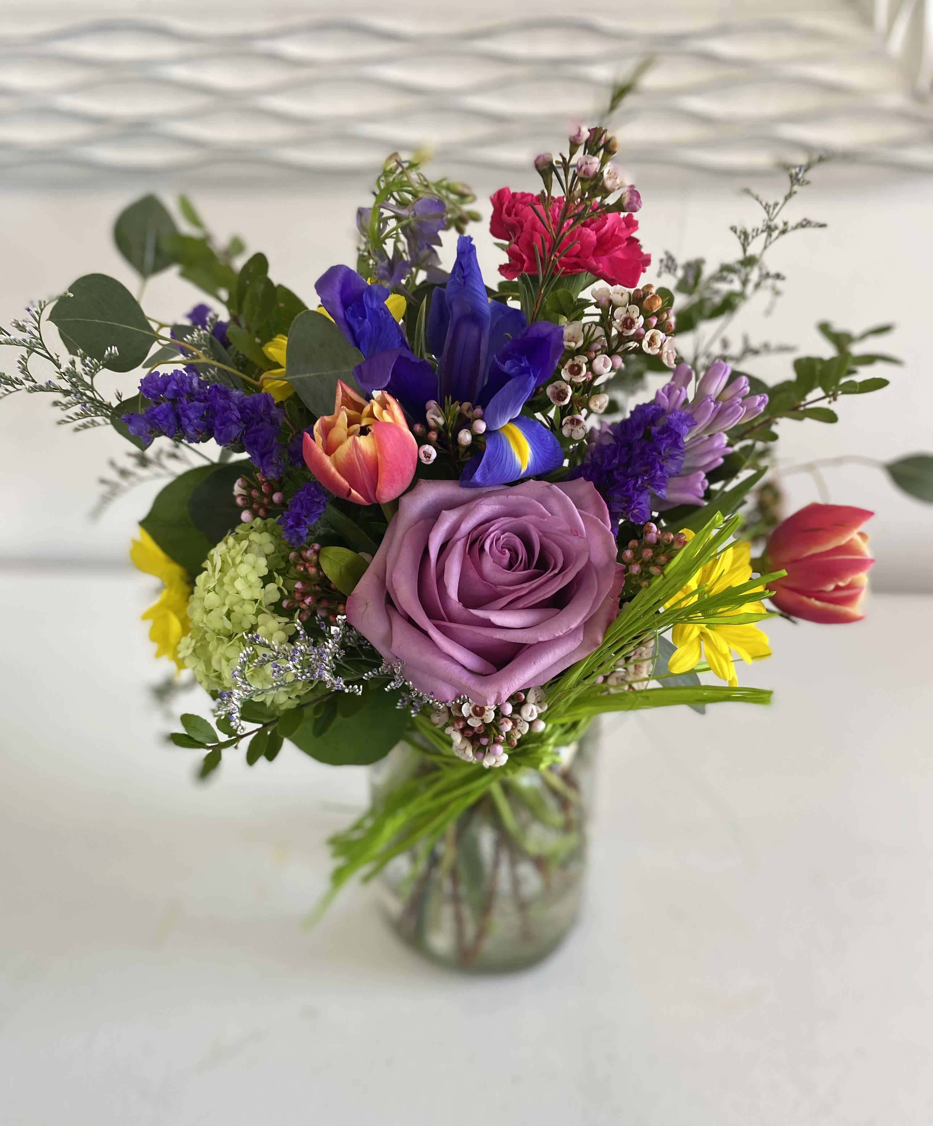 Mixed bouquet with a lavender rose in a glass vase