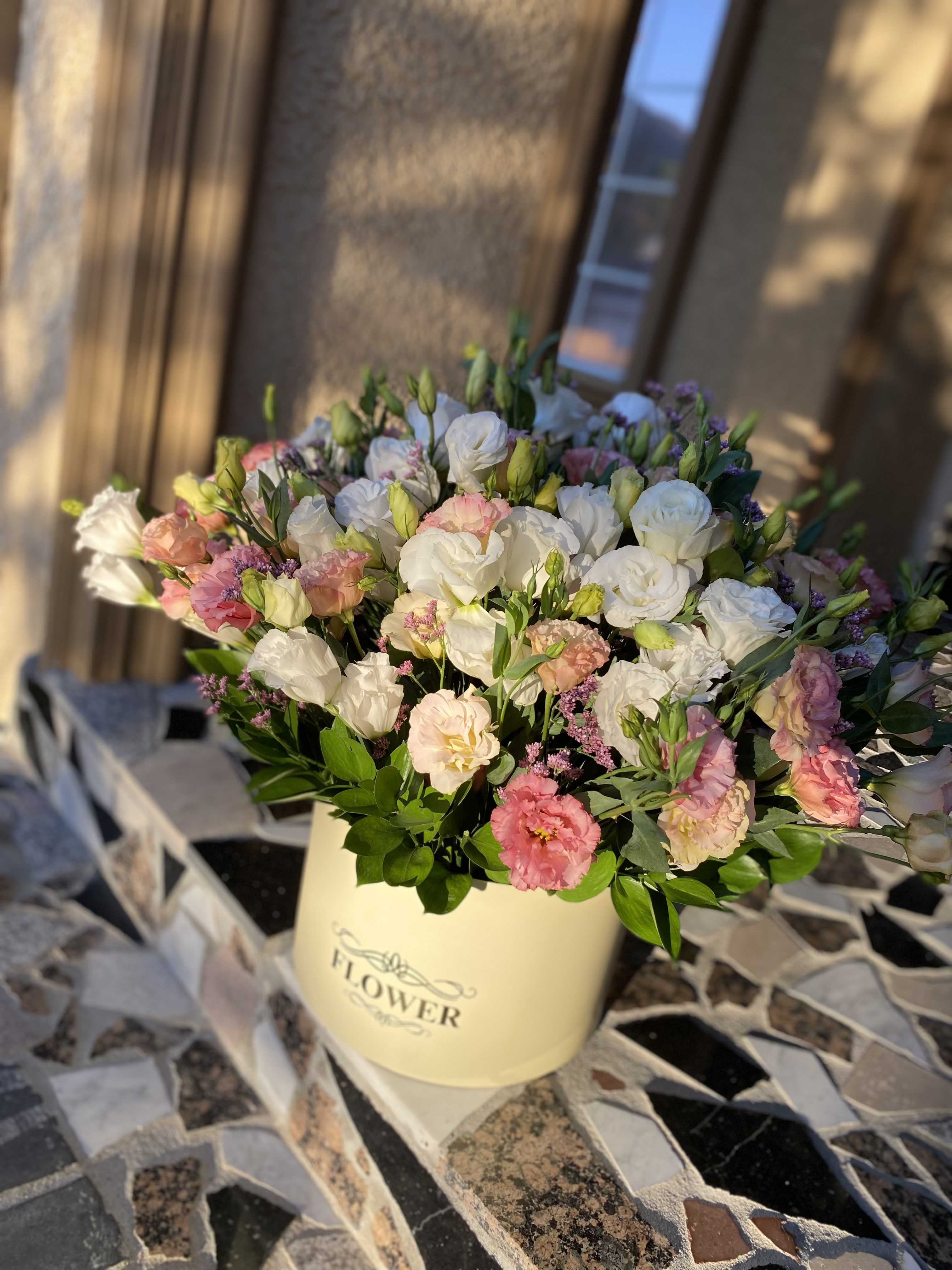 Mixed pink and white flowers in a cream hatbox