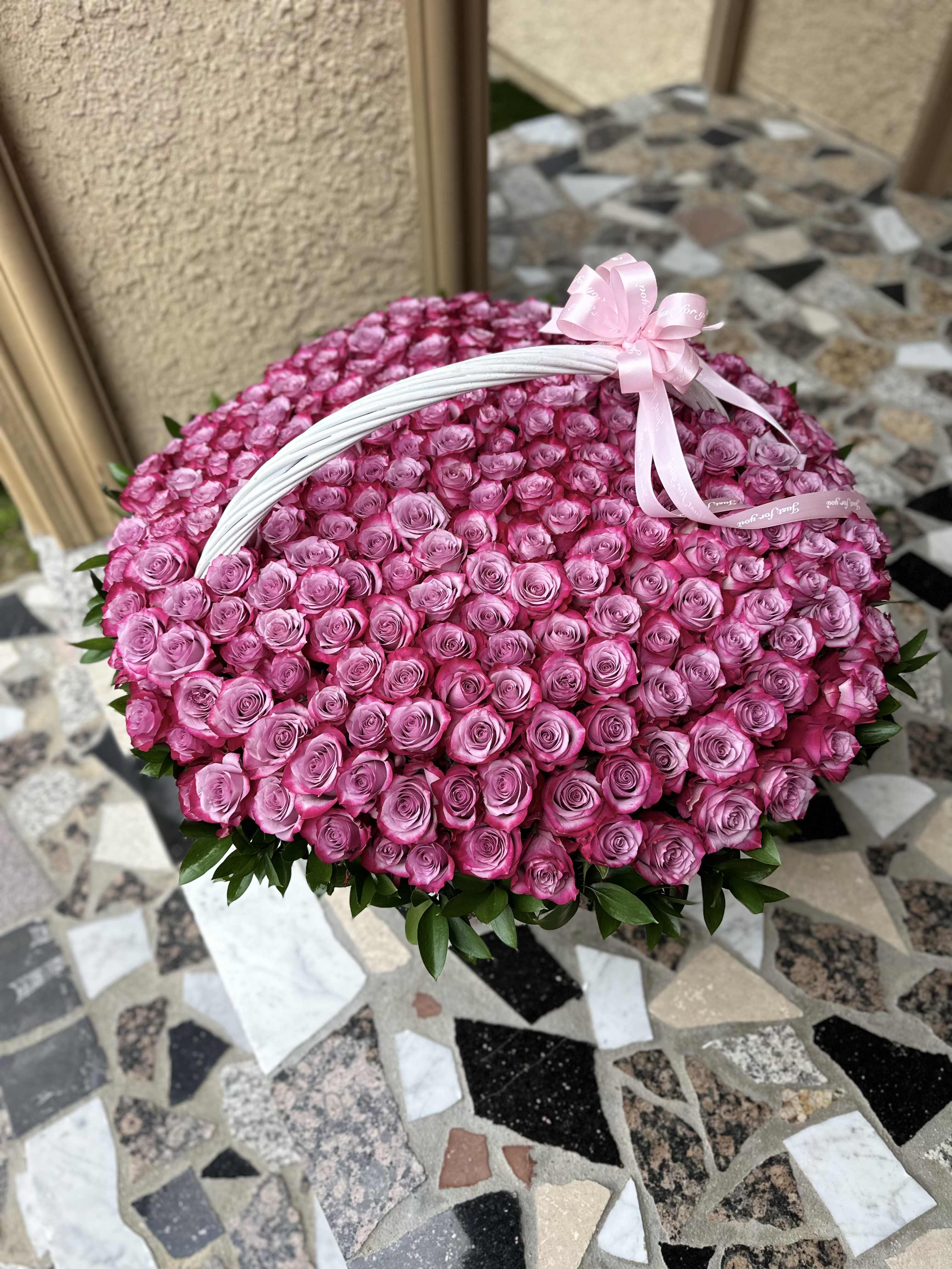 Large basket of pink roses with a ribbon bow