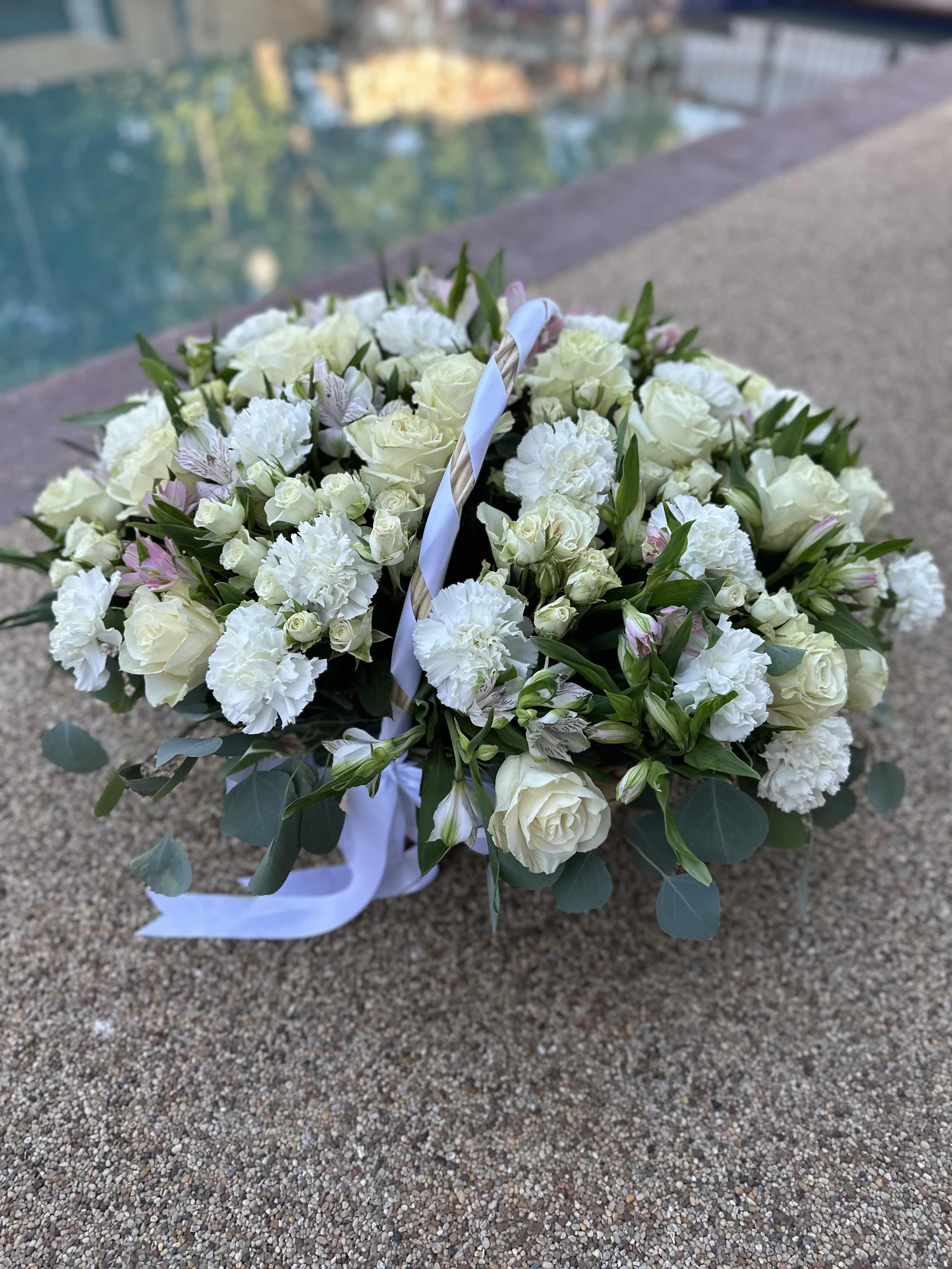 Large white floral basket arrangement with roses and carnations