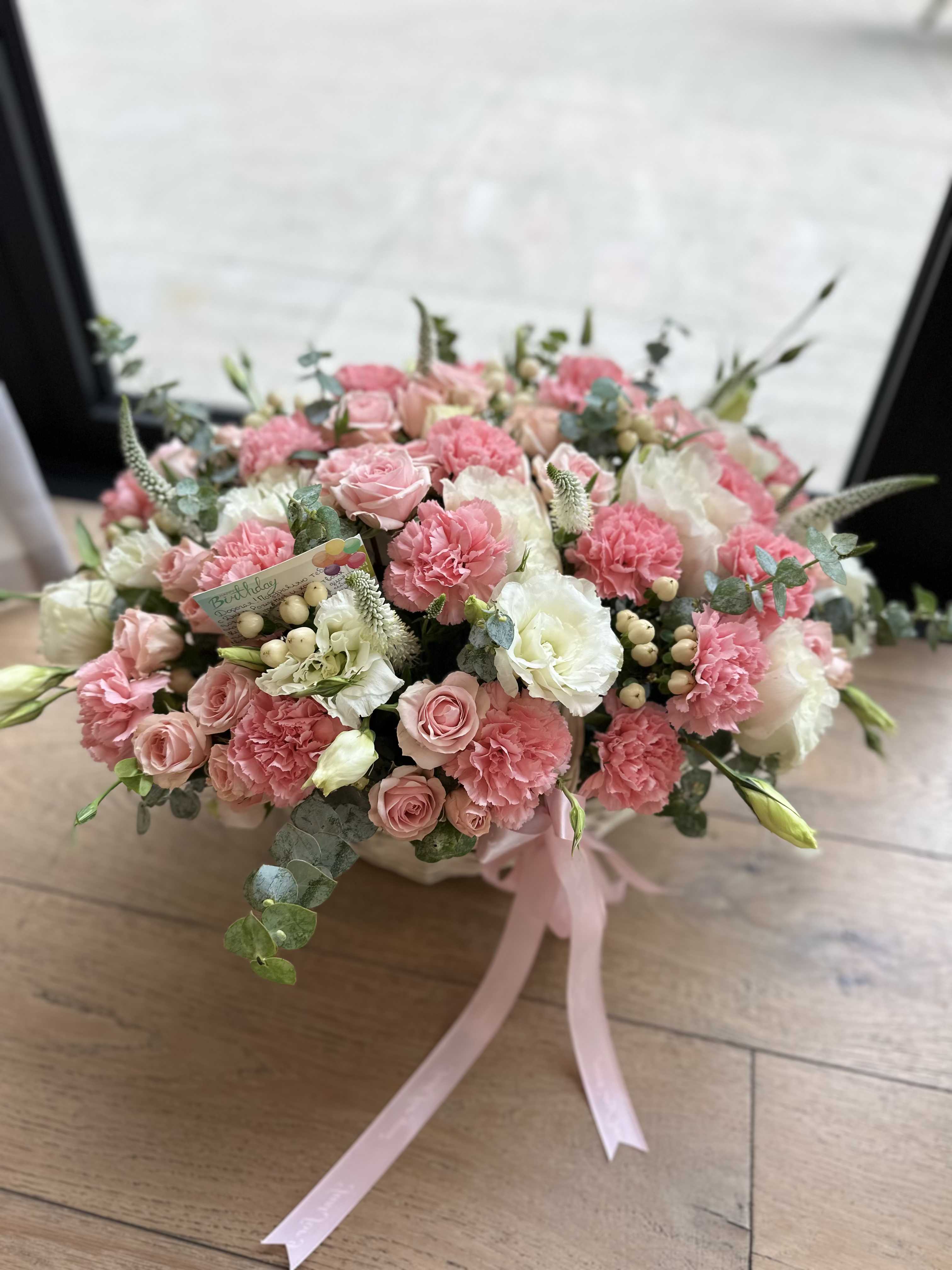 Pink and white bouquet with roses and carnations tied with a ribbon