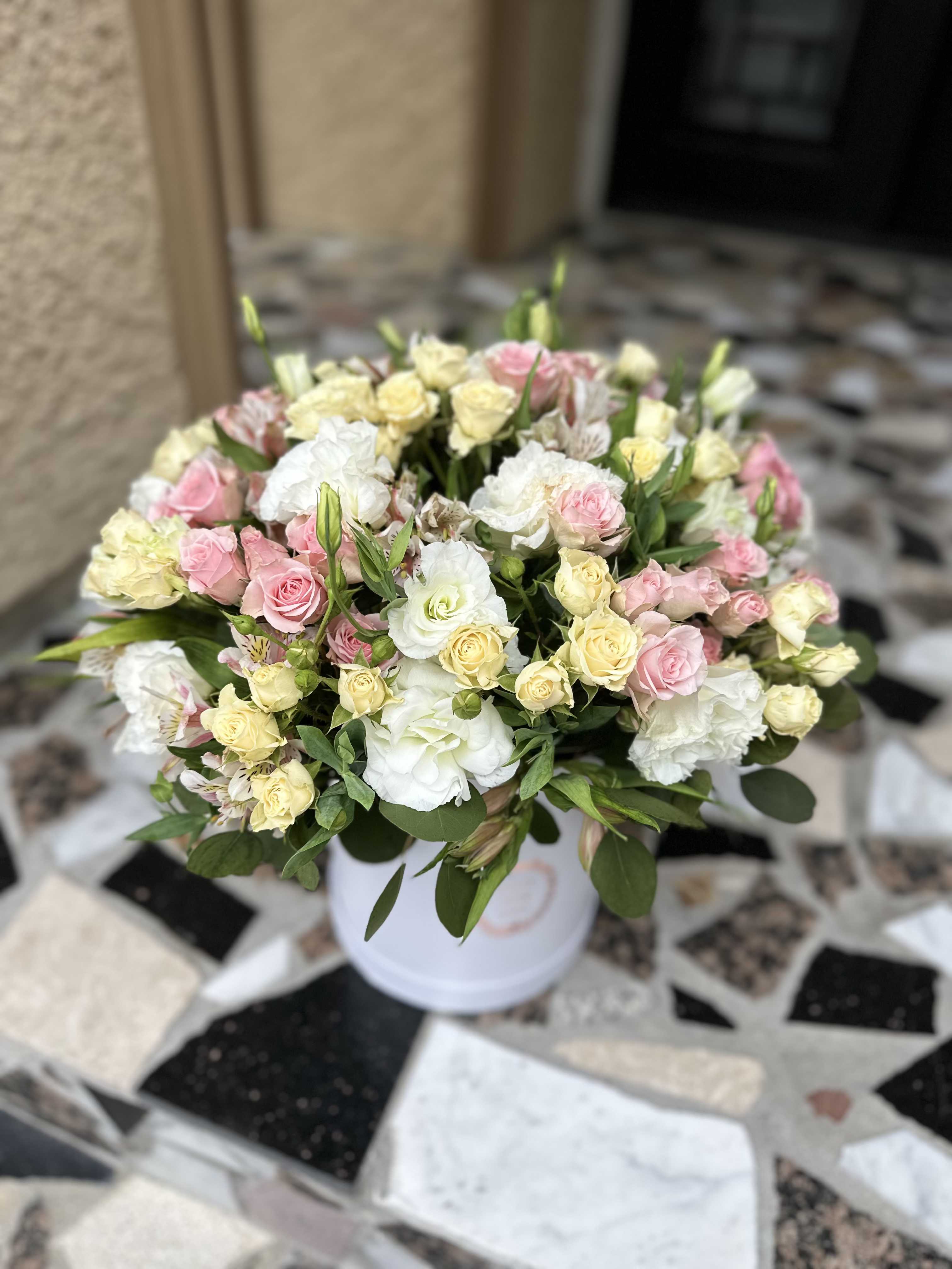 Bouquet of pink and cream roses in a white vase