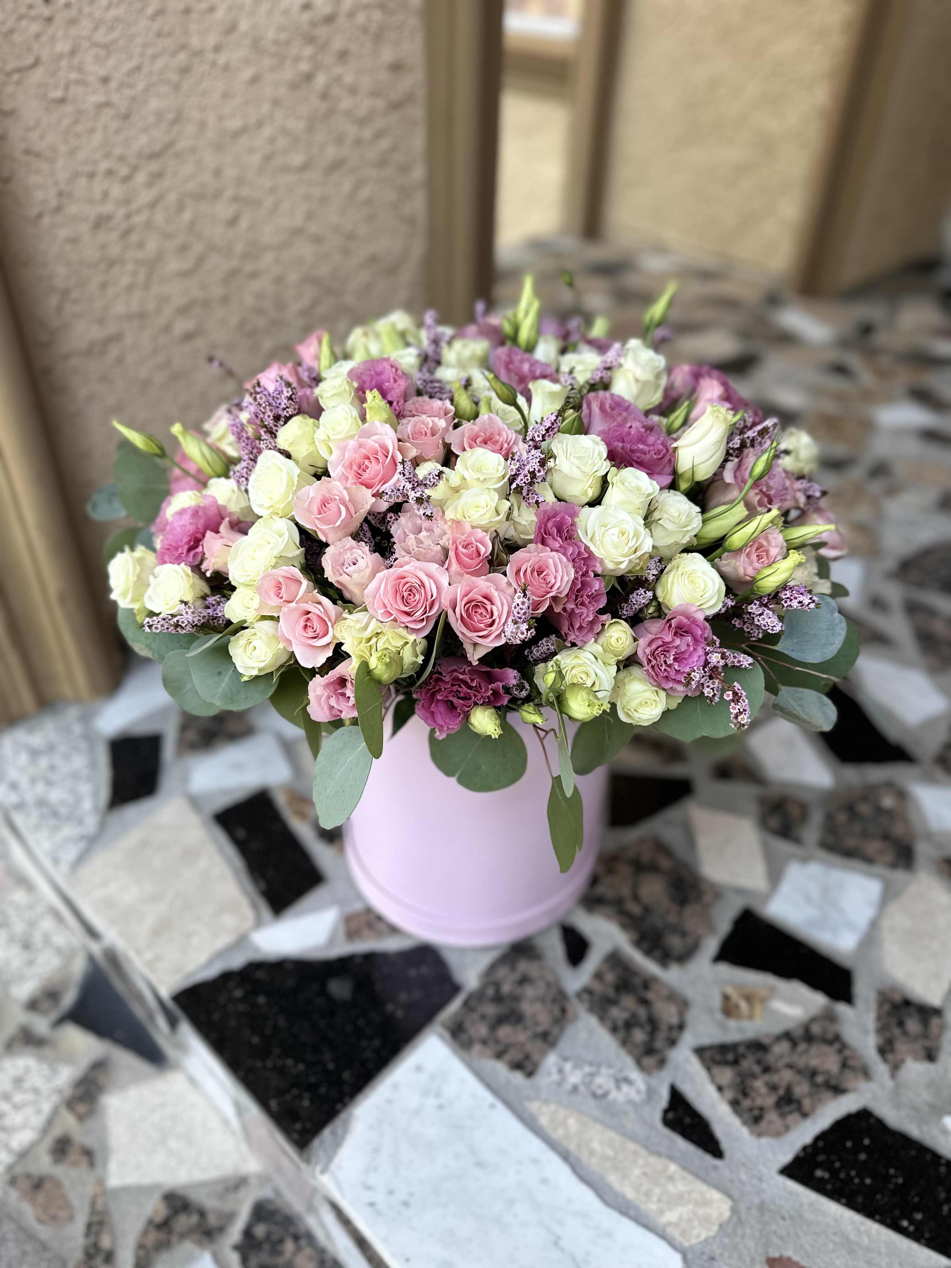 Pink and white rose bouquet in a light pink vase