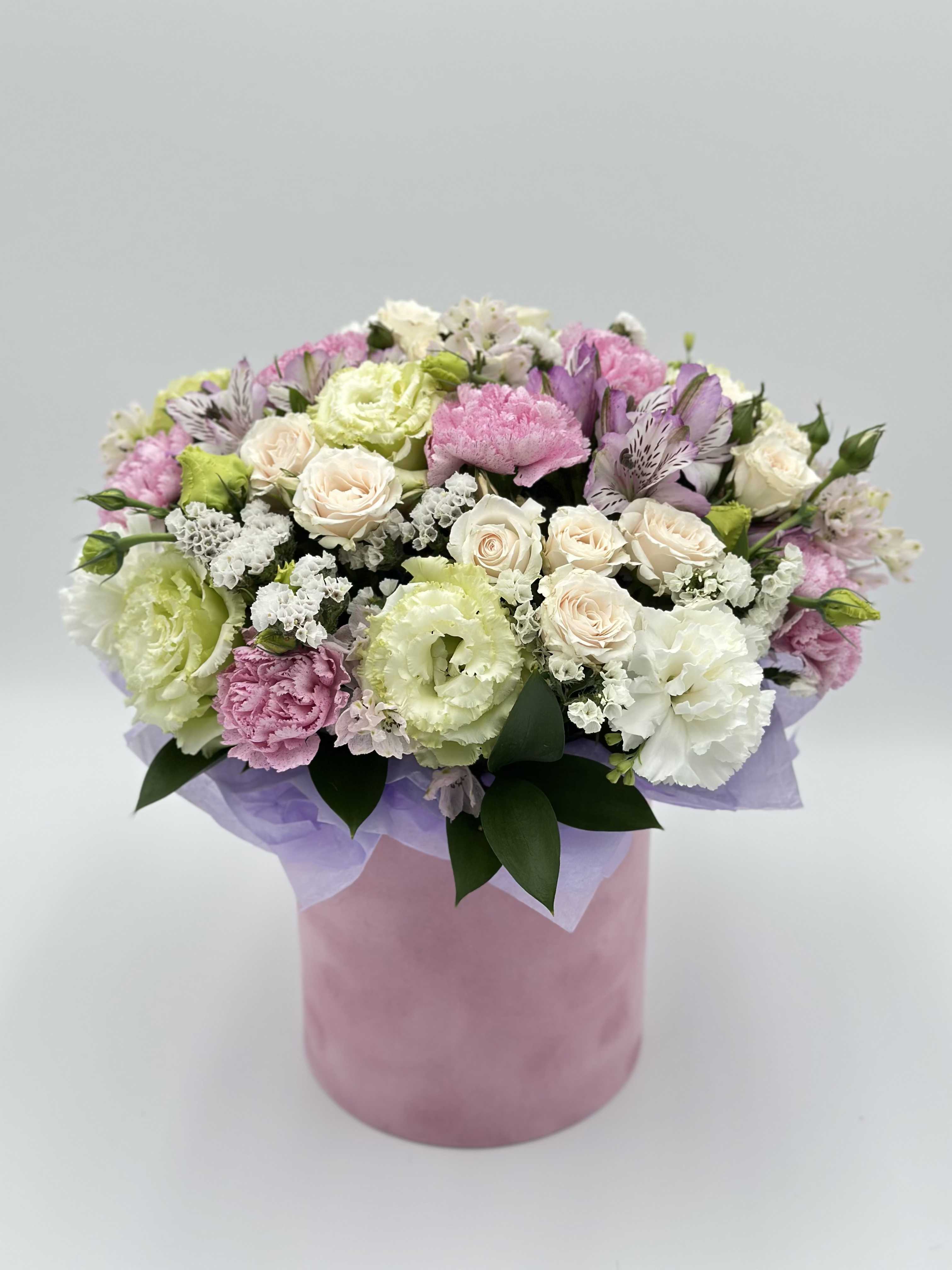 Pastel bouquet of roses, carnations, and alstroemeria in a pink box