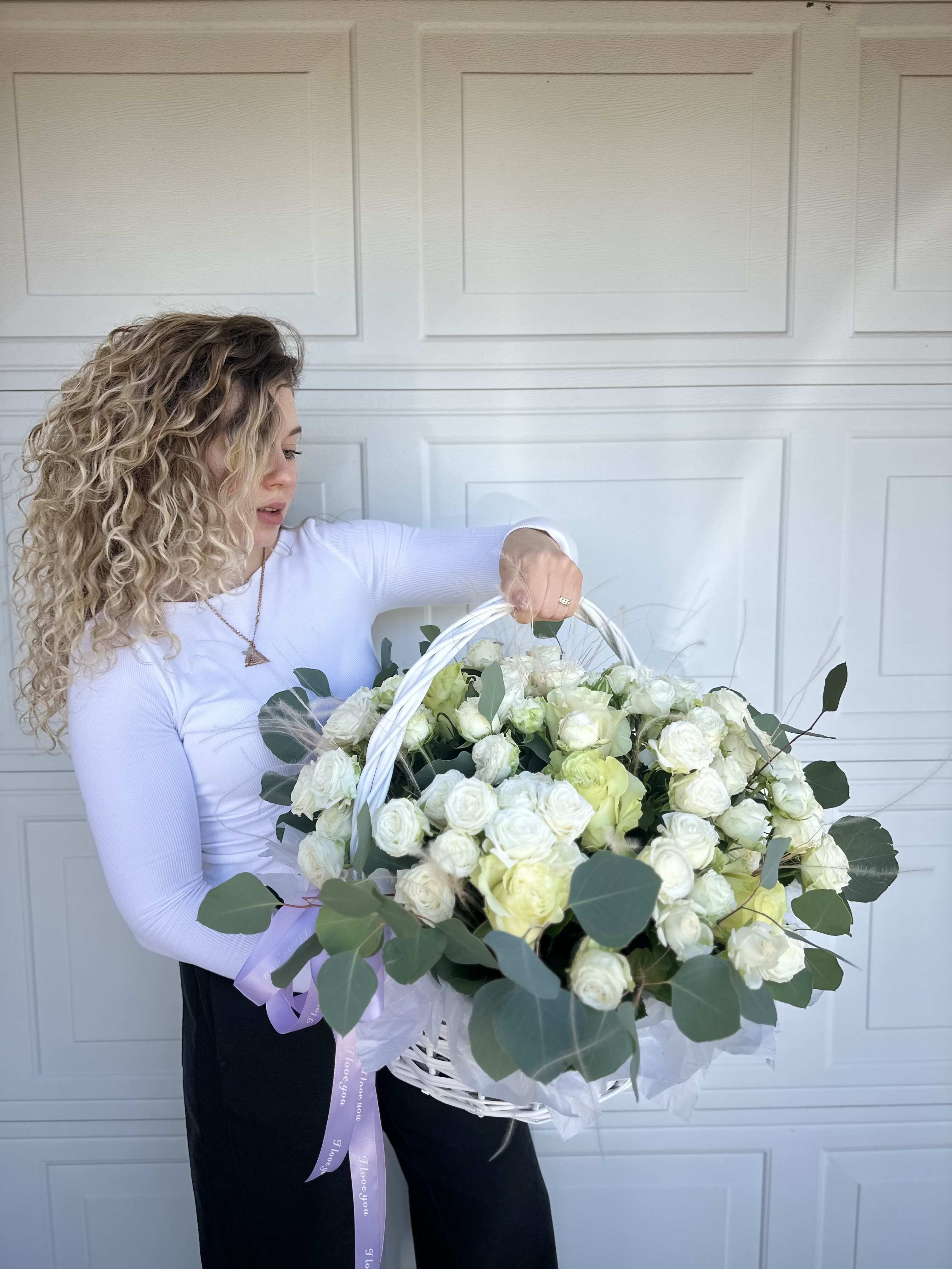Large white basket of white and pale green roses with eucalyptus