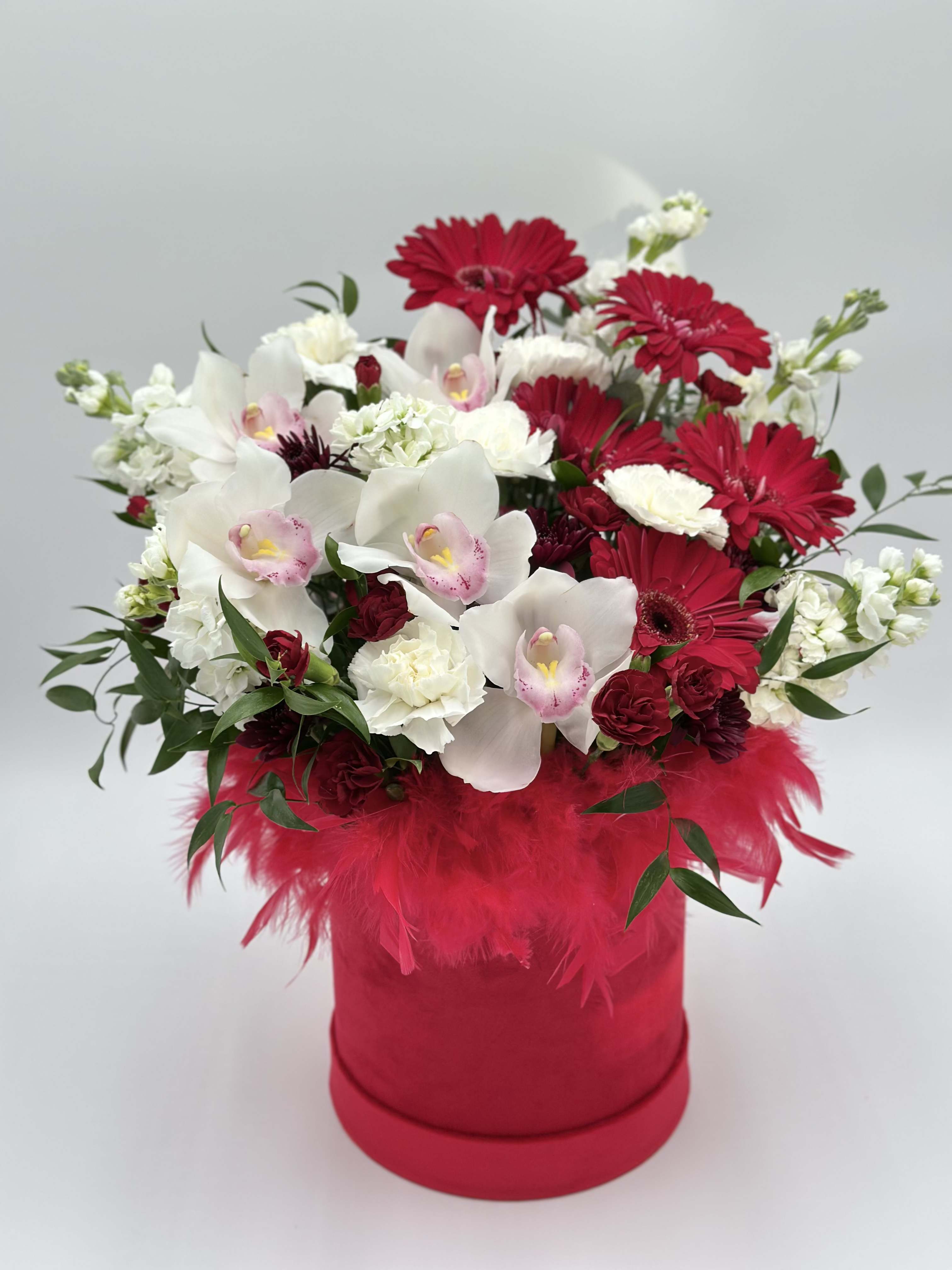 Red and white mixed bouquet in a pink hatbox