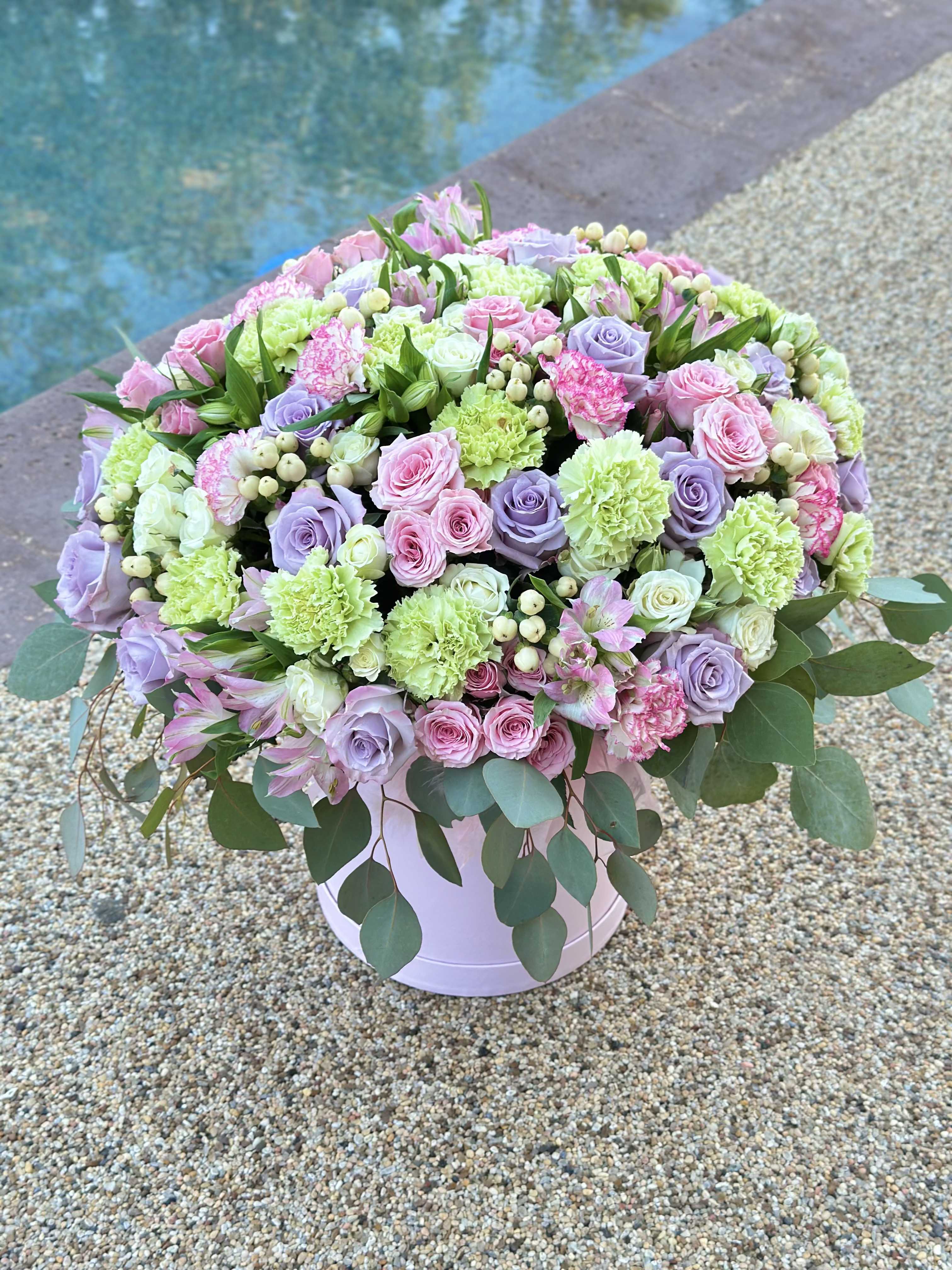 Large pastel bouquet of roses, carnations, and alstroemeria in a round box