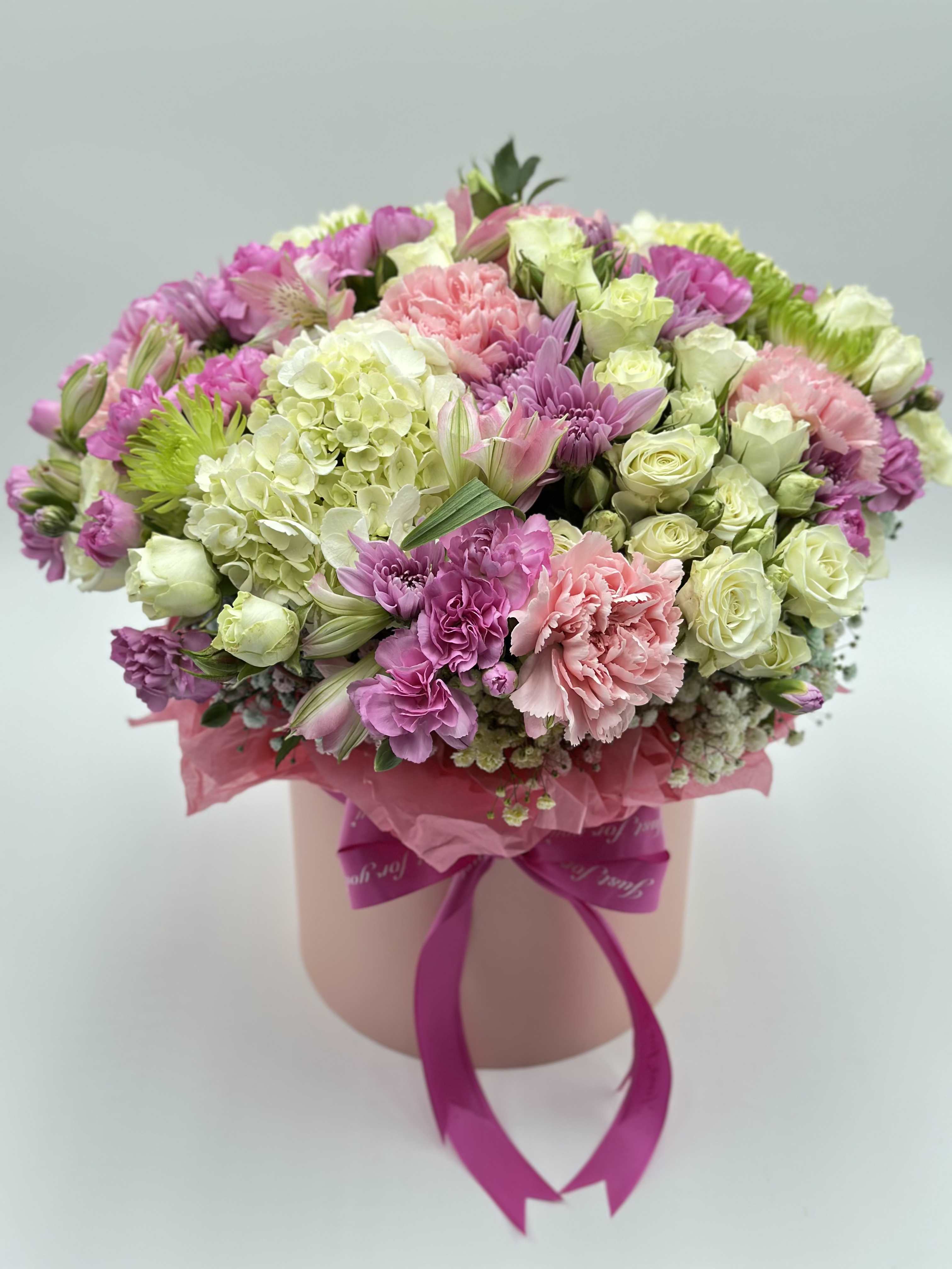 Pink and white mixed bouquet in a round box with a ribbon