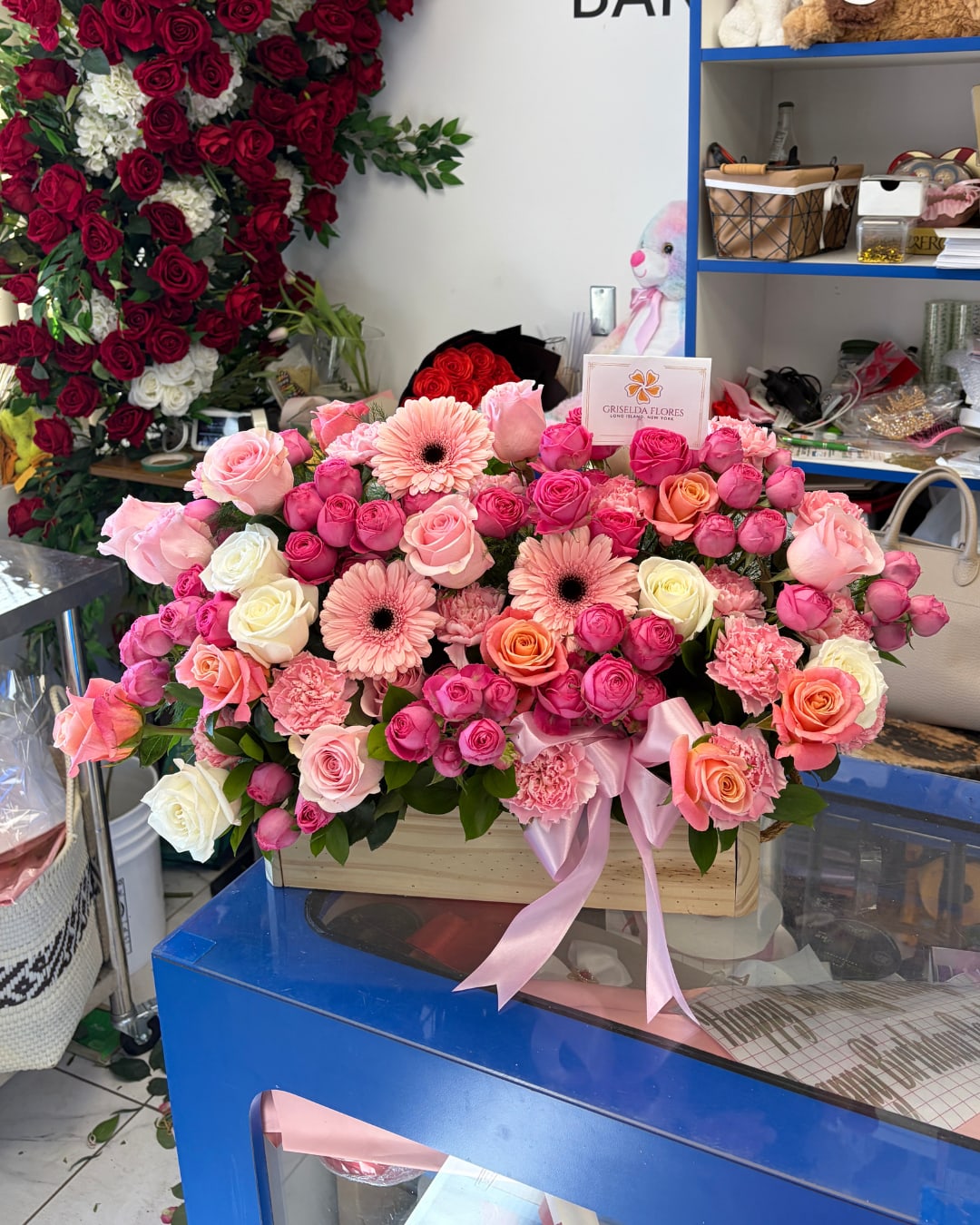 Large pink and red rose arrangement with gerbera daisies in a wooden box