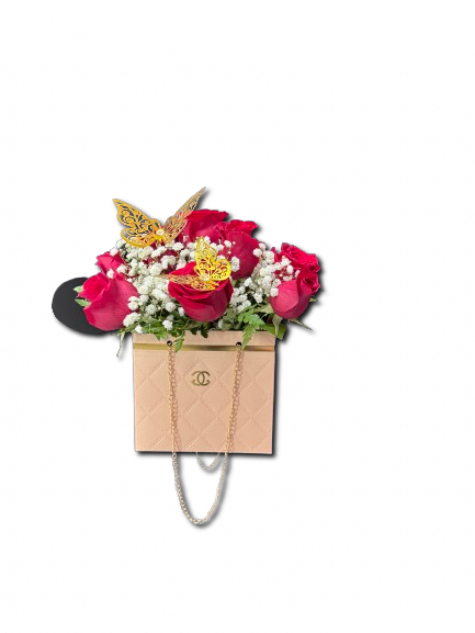 Pink roses with white filler flowers in a blush handbag-style box with gold butterflies.