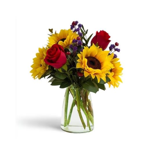 Bouquet of sunflowers and red roses in a clear glass vase