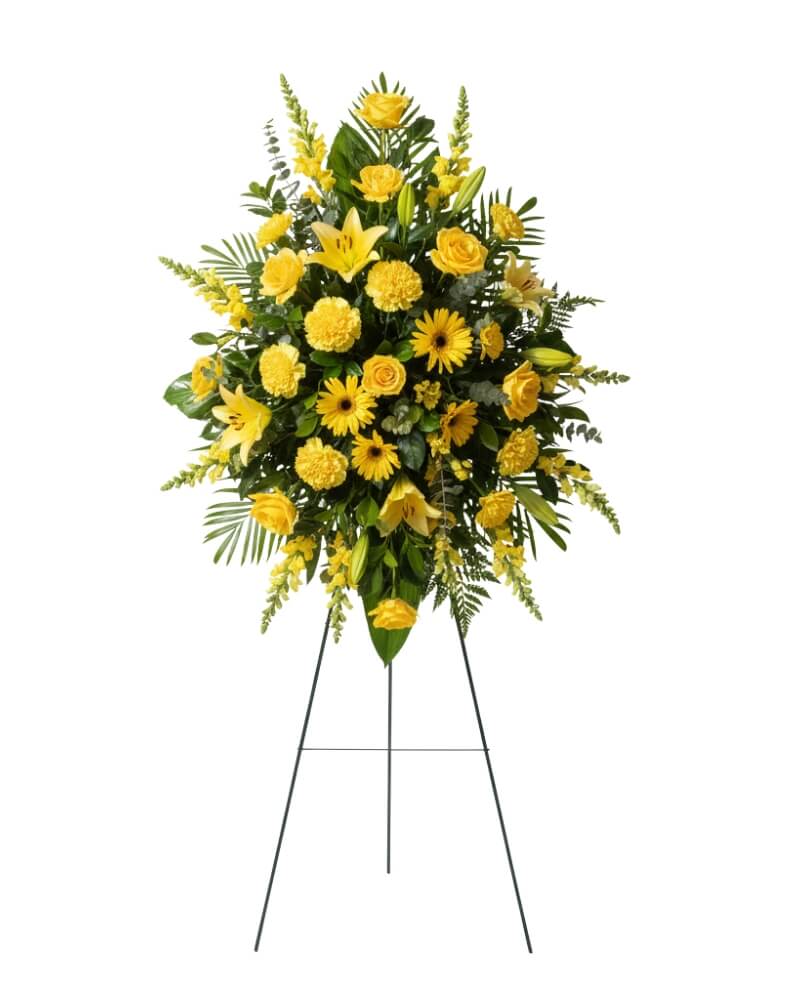 Eternal Sunshine Standing Spray  - This teardrop-shaped standing spray serves as a vibrant focal point for a memorial service. Set upon a wire easel, it stands tall as a testament to a bright and enduring spirit.