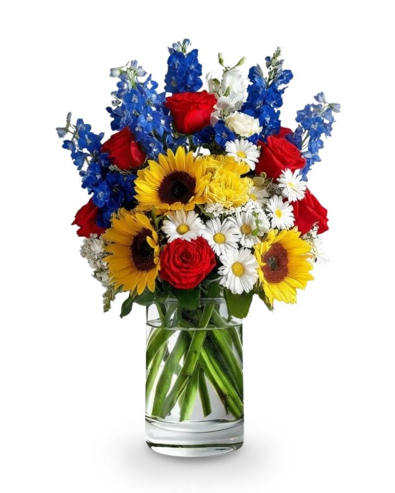 Stars &amp; Stems - Celebrate the spirit of Independence Day with this tall and radiant display of patriotic pride. 'Stars &amp; Stems' features a bold red, white, and blue palette elevated by golden sunflowers and cheerful daisies. This vibrant arrangement is a joyful tribute to freedom and unity—perfect for parades, backyard barbecues, or any place that deserves a splash of July 4th color. Bursting with height and energy, it’s as grand as the celebration itself.