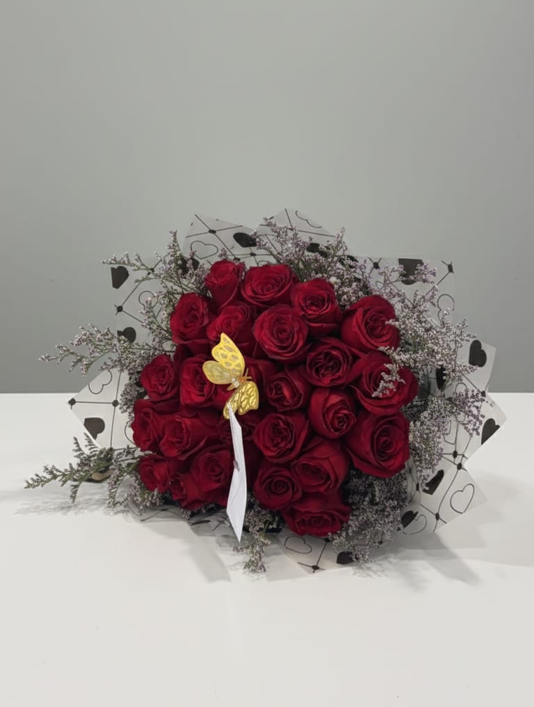 Bouquet of red roses with delicate filler and heart-patterned wrap
