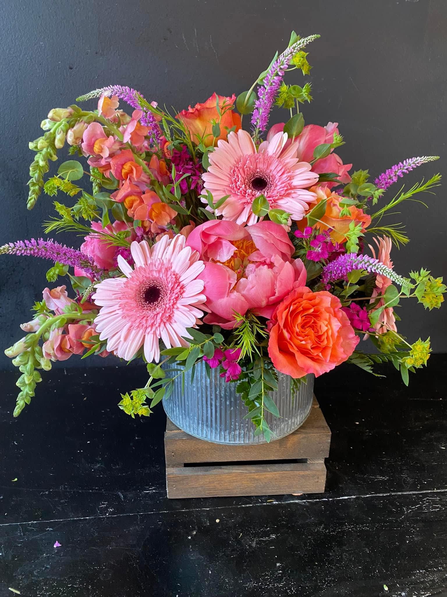 Bright pink and orange mixed bouquet in a ribbed metal container