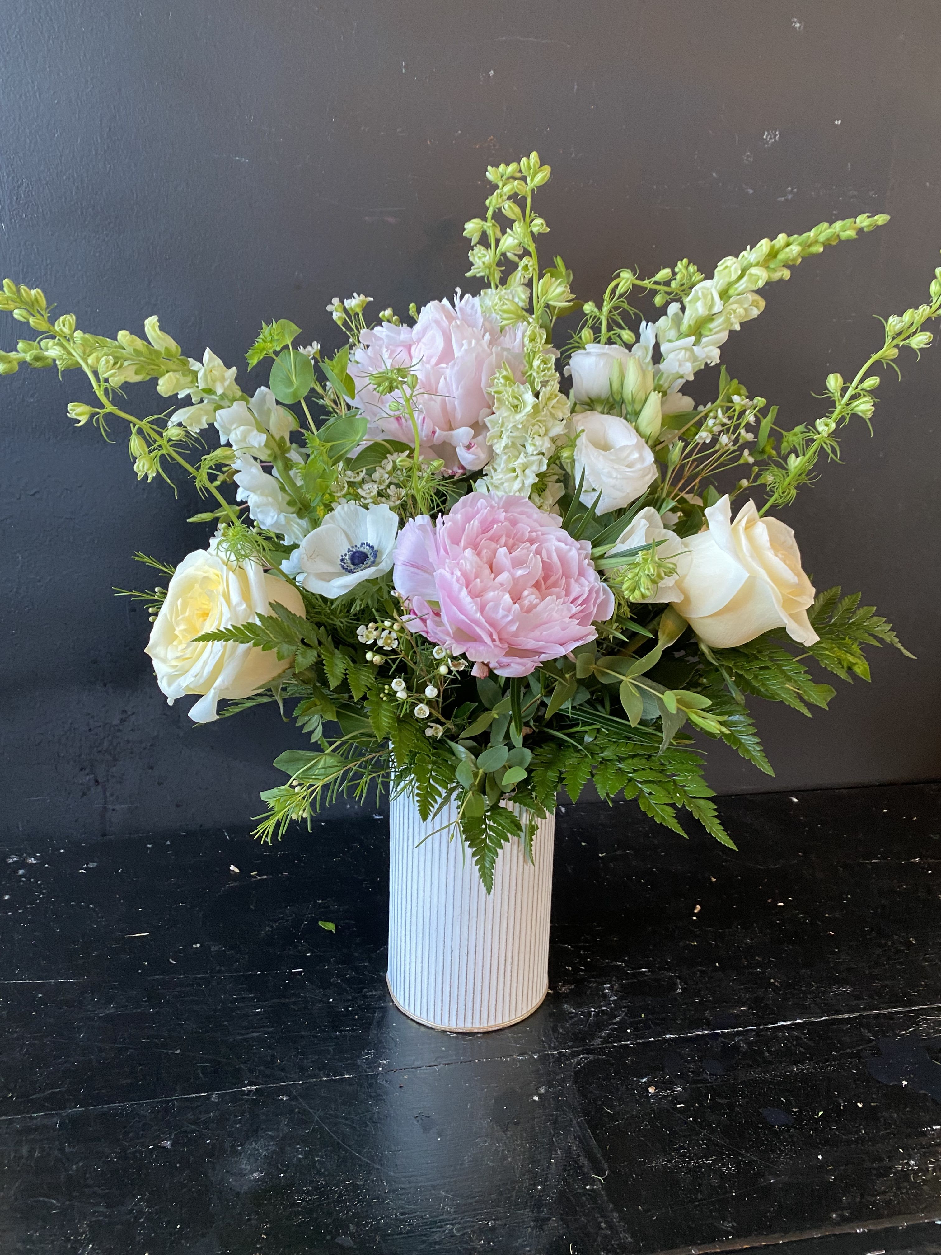 Pink and white floral arrangement in a ribbed white vase