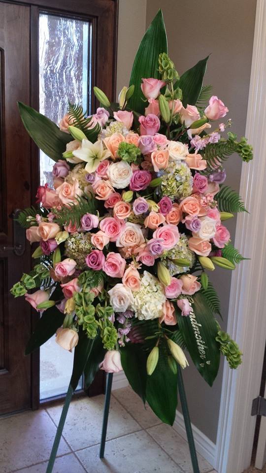 Large pastel rose and lily standing spray on an easel
