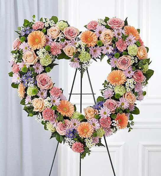 Always Remember  Floral Heart Tribute- Pastel - The warm and gentle love they showed to those around them will keep them always remembered. This sentiment is best captured with our standing, open heart-shaped arrangement in pastel hues. Handcrafted by our caring florists with an assortment of soft, pastel blooms, it is a magnificent tribute fitting for the funeral services.