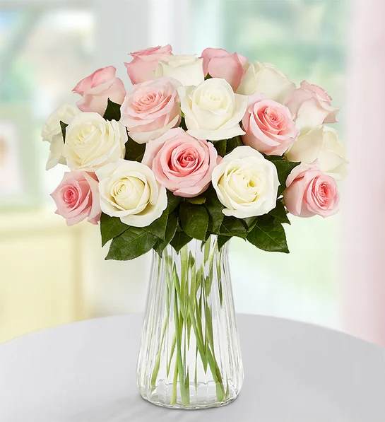 Bouquet of pink and white roses in a clear glass vase