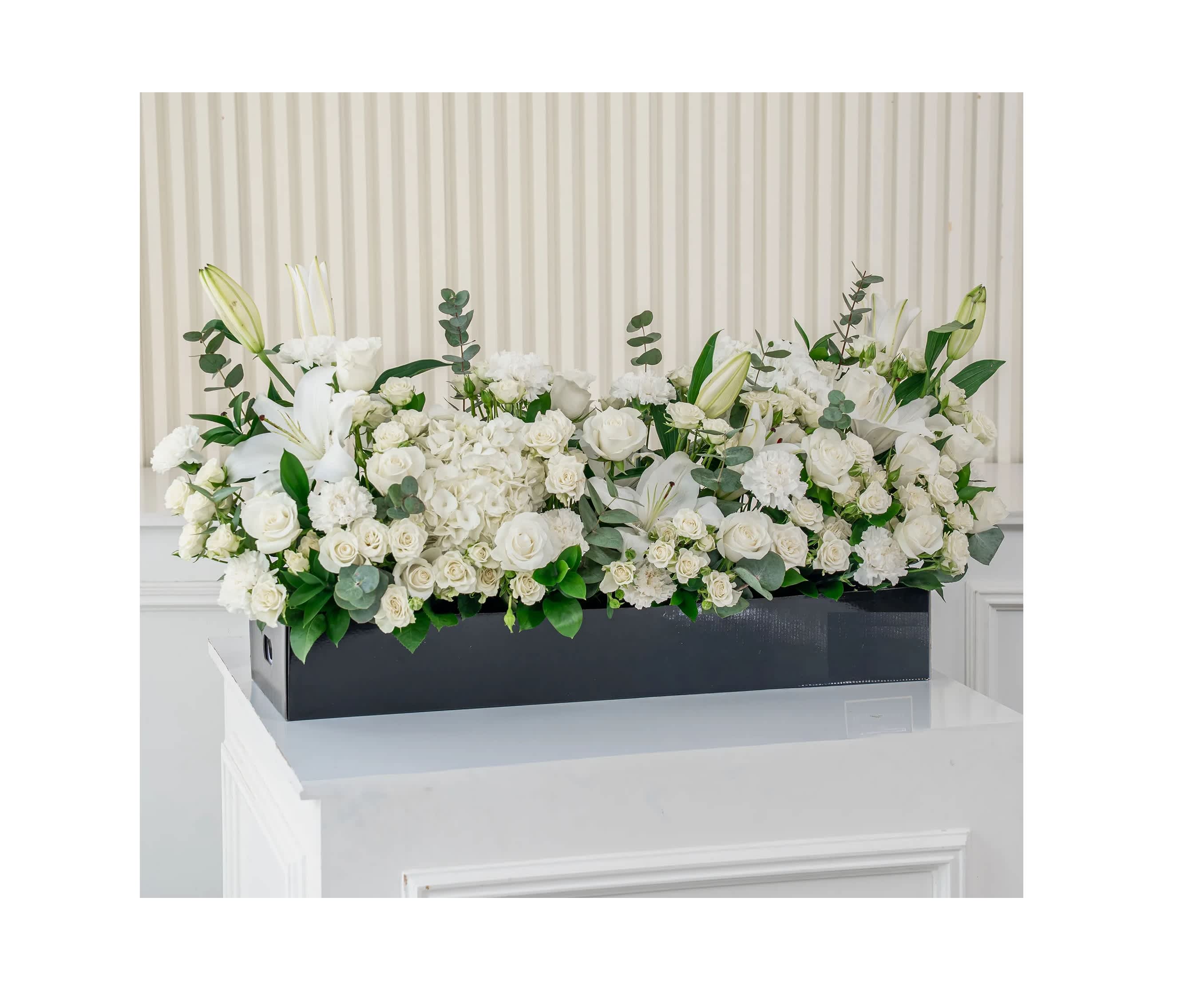 White floral arrangement in a black rectangular box