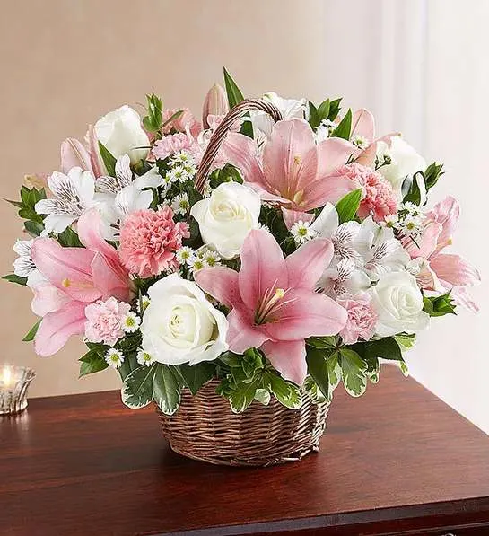 Peace &amp; Blessings   Pink &amp; White basket  - Representing care, compassion and love - pink blooms can offer solace in times of sorrow. Artistically designed inside a keepsake willow basket, our arrangement in soothing pink hues is a touching way to offer your sincerest blessings.  white roses, alstroemeria and monte casino and pink Asiatic lilies, carnations and mini carnations; accented with fresh greenery