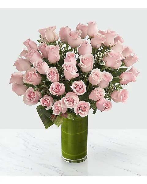 Pink roses arranged in a tall green vase