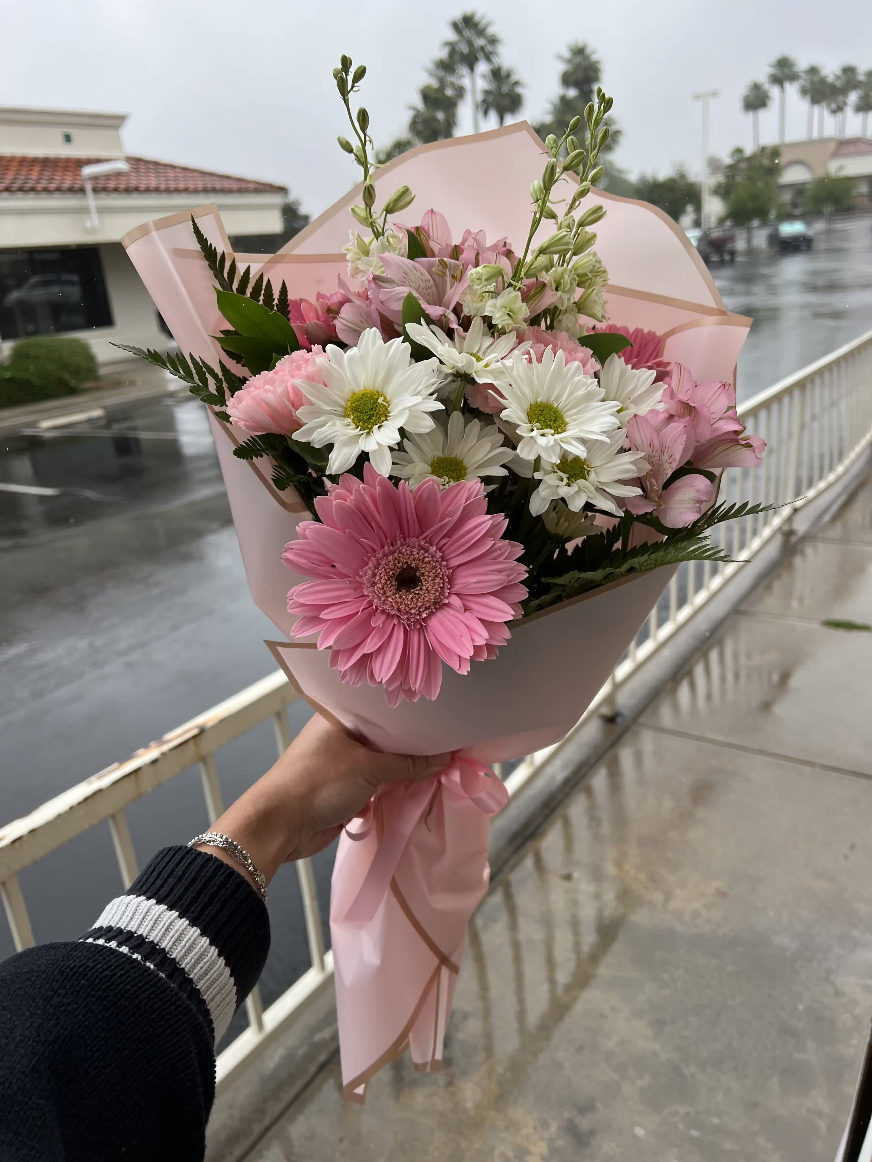 Pink bouquet with gerbera daisies and white daisy flowers wrapped in pink paper